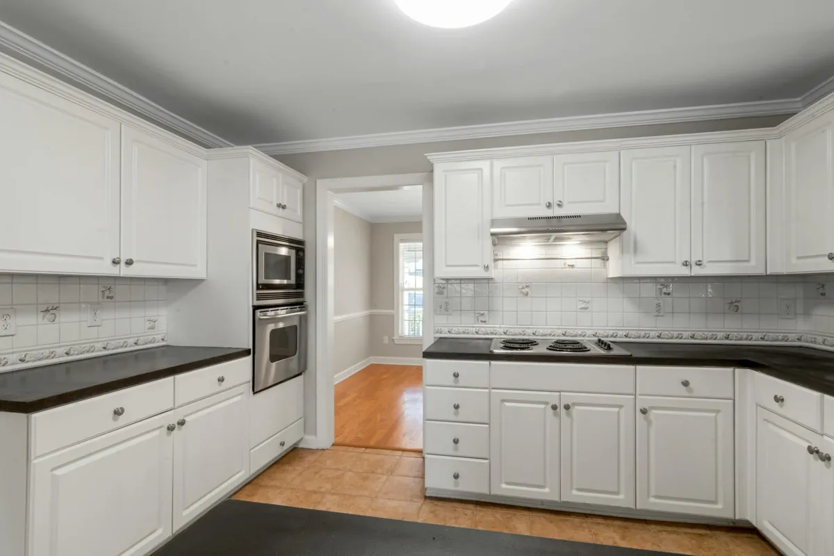 A kitchen mid-renovation with cabinet doors removed and paint supplies